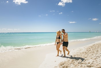 On the beach, white sand, beach cabanas, beach umbrellas