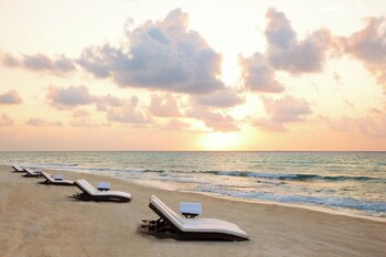 On the beach, white sand, sun loungers, beach umbrellas