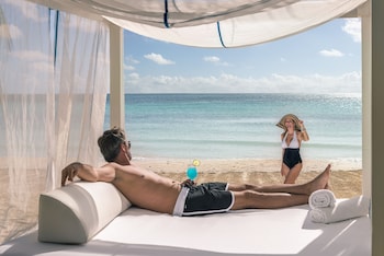 On the beach, white sand, sun loungers, beach umbrellas