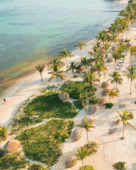 On the beach, white sand, beach cabanas, sun loungers