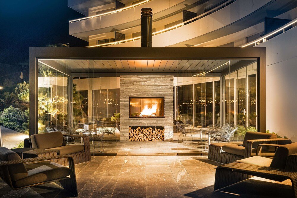 Patio exterior con chimenea y paredes de vidrio en 7132 Hotel