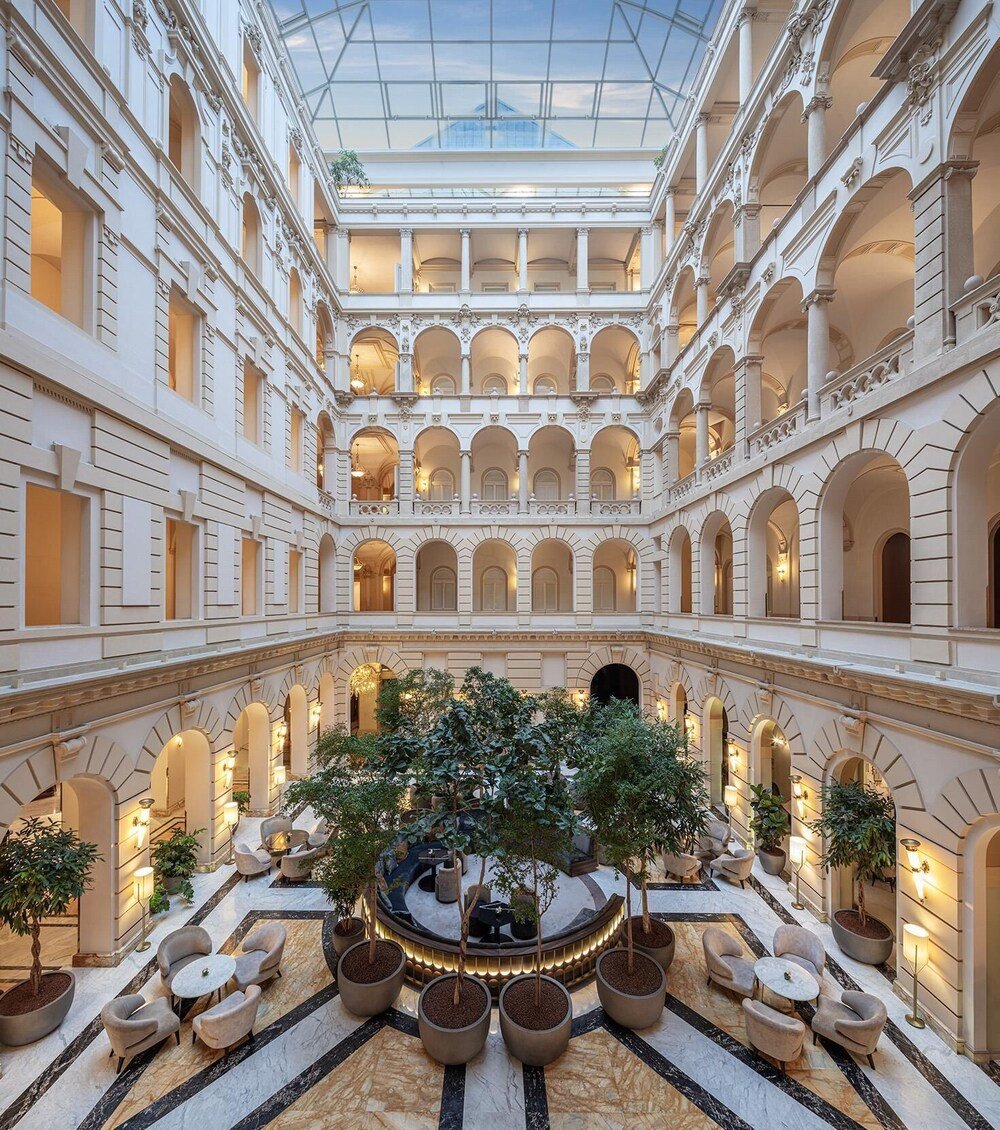 Spacious atrium with a central garden inside the historic palace