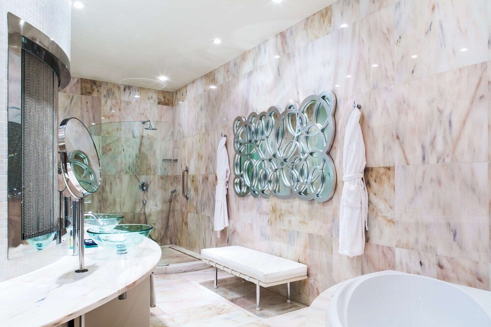 Bathroom with a marble wall and a glass shower enclosure