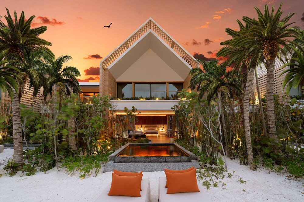 Modern building with a triangular roof, pool and palm trees at Banyan Tree Mayakoba