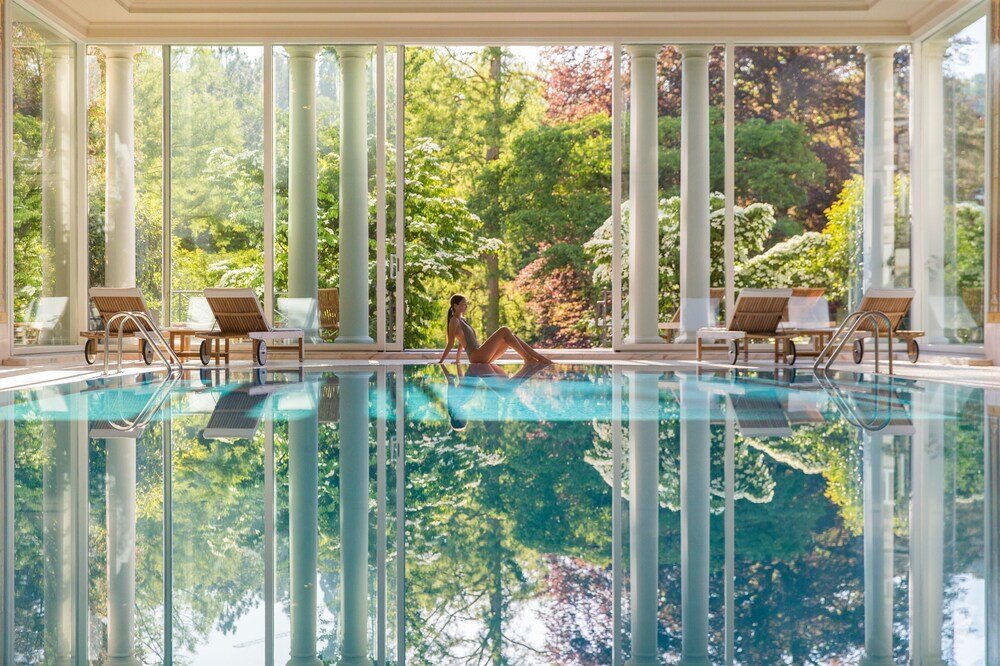 Pool surrounded by columns and lounge chairs inside the hotel spa