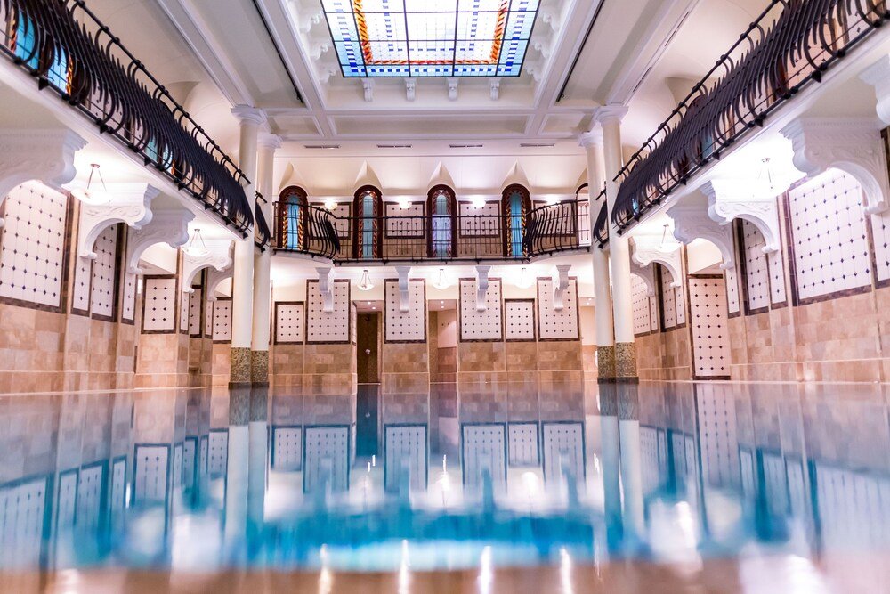 Spacious indoor pool with ornate railings and classical details