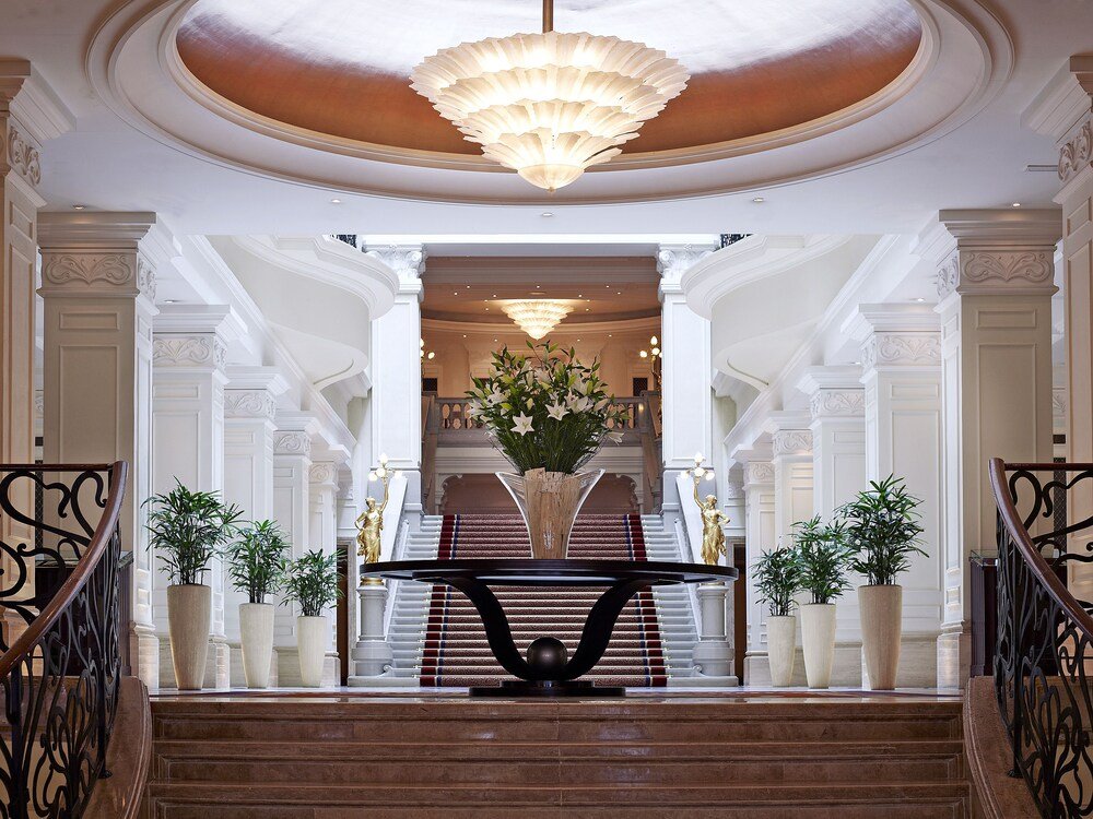 Grand staircase with a large chandelier in the hotel lobby