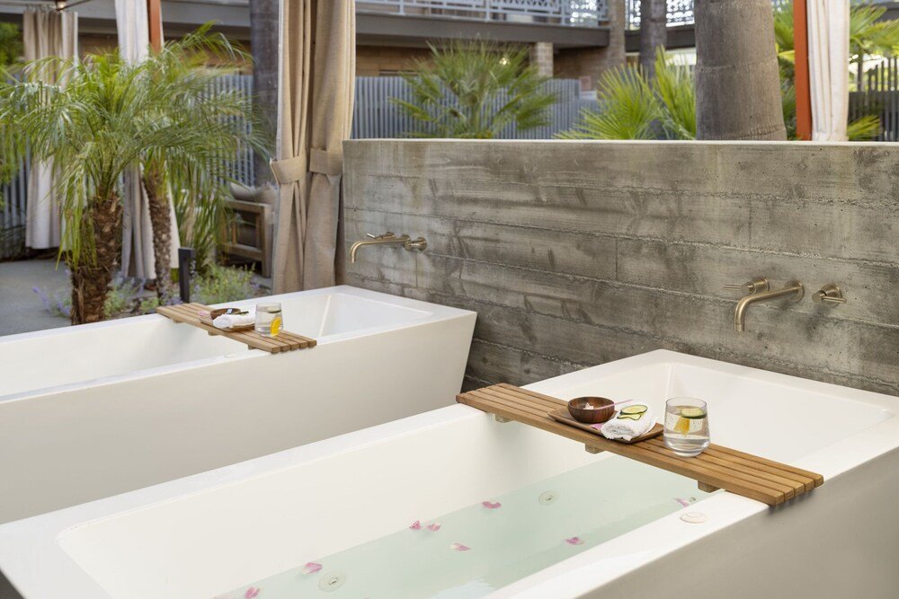 Spa area with two large white tubs and wooden shelves
