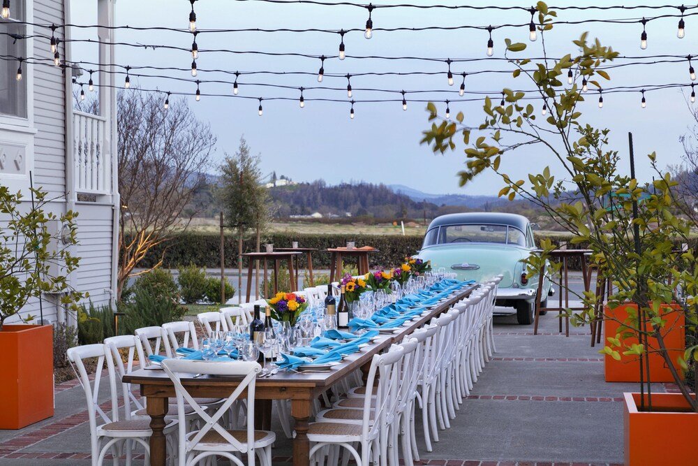 Long dining table set outdoors under string lights