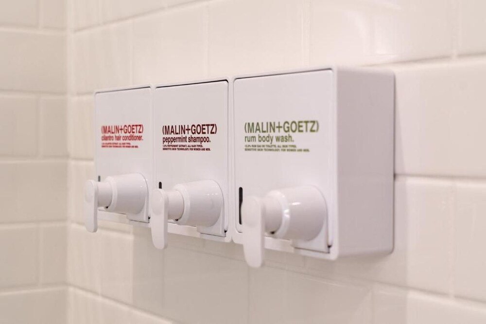 Three white dispensers mounted on a spa wall