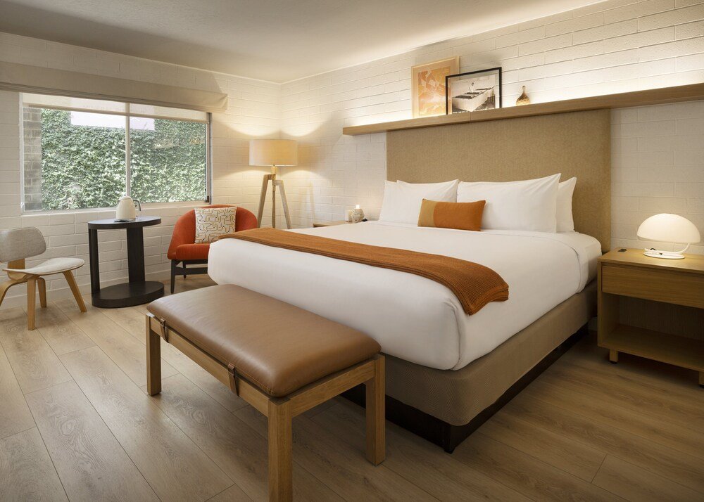Hotel room with a large bed and a bench