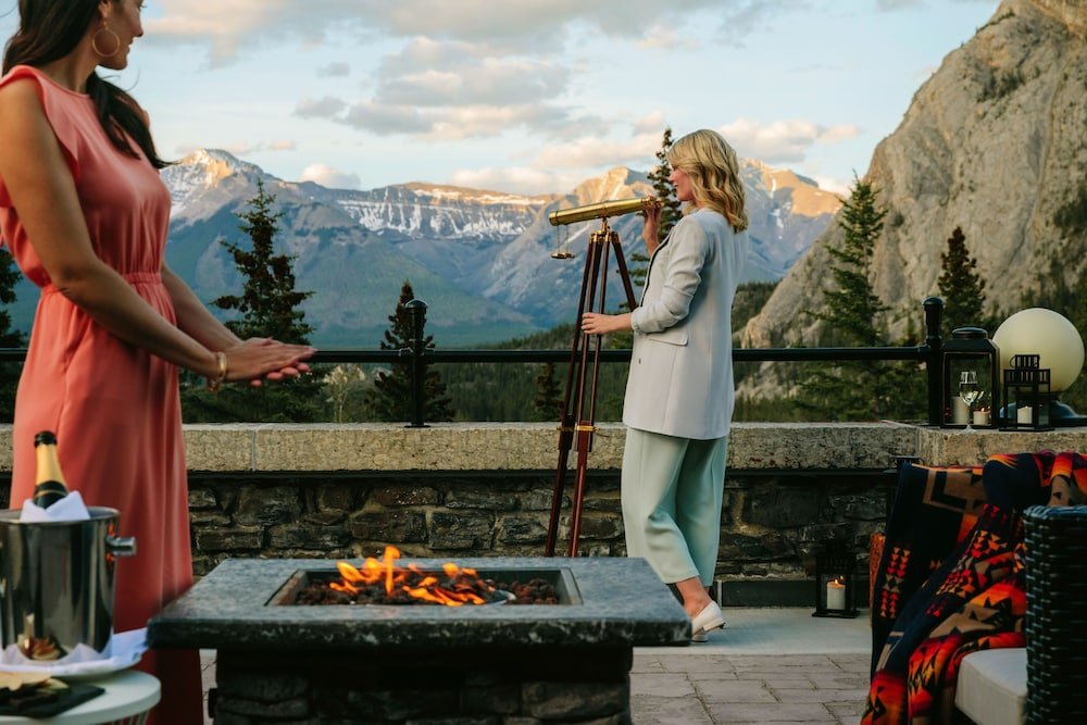 Terrace with a stone fireplace, a telescope and mountain views