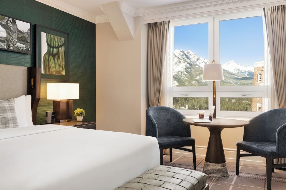 Hotel room with a large bed and two armchairs