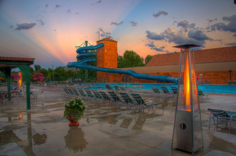 Pool area with lounge chairs and a water slide