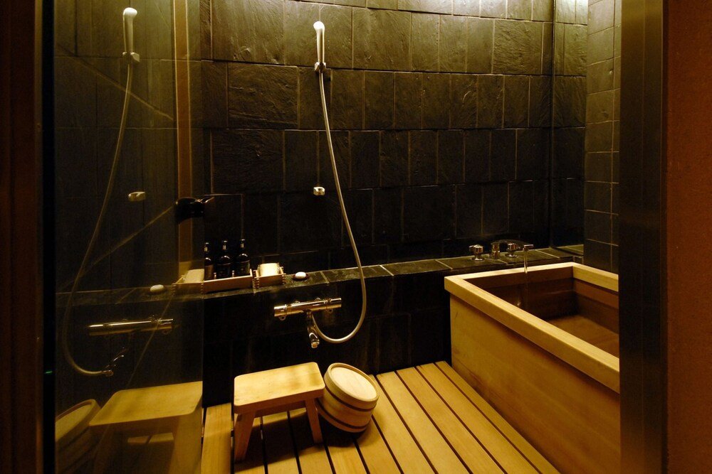 Baño moderno con un banco de madera y bañera profunda