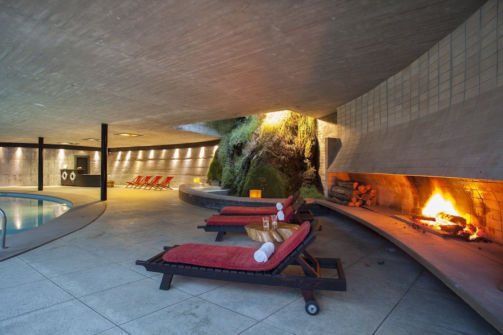 Spa area with a pool, lounge chairs and a fire feature