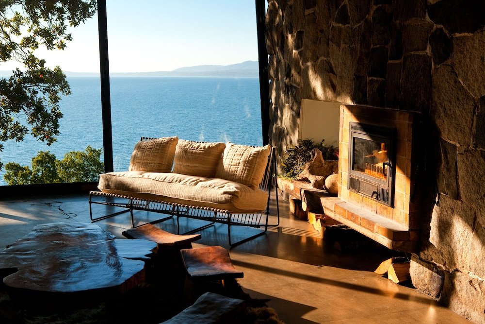 Cálido living con chimenea de piedra y sillones