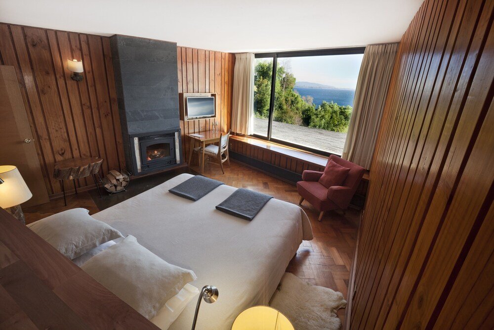 Dormitorio con una chimenea y vista al entorno del hotel