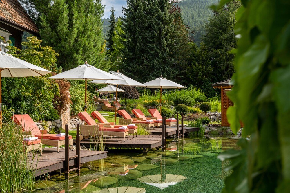 Serene outdoor pool area with lounge chairs and green surroundings