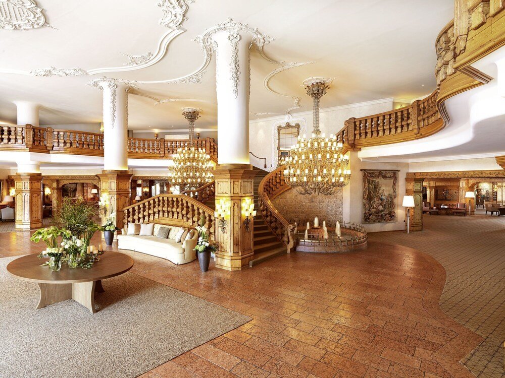 Gran lobby del hotel con escalera central y arañas de cristal