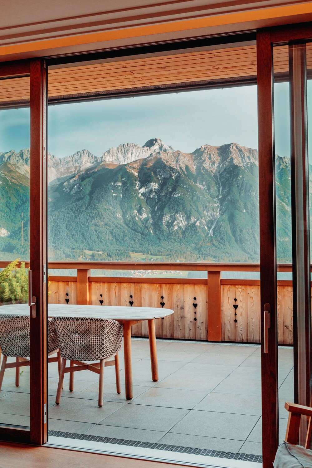 Balcón del hotel con mesa y sillas de madera y vista al paisaje