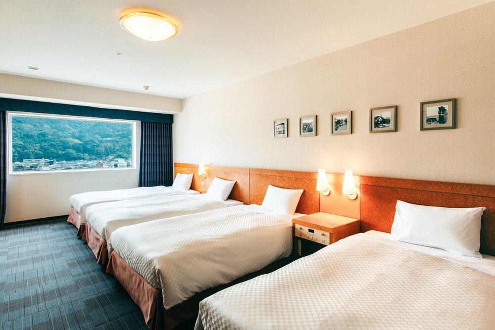 Habitación del hotel con gran ventanal y vista a la ciudad