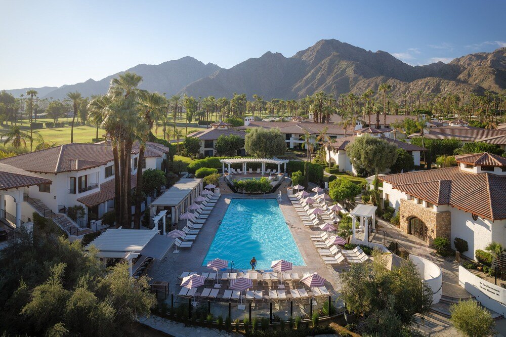 Resort grounds with a central swimming pool and lounge chairs