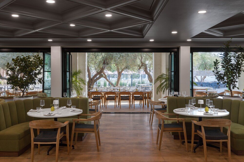 Salón del restaurante con mesas redondas y asientos verdes