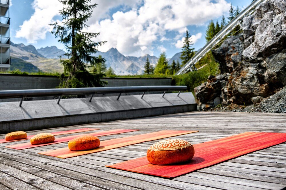 Wooden deck with yoga mats and decorative pillows