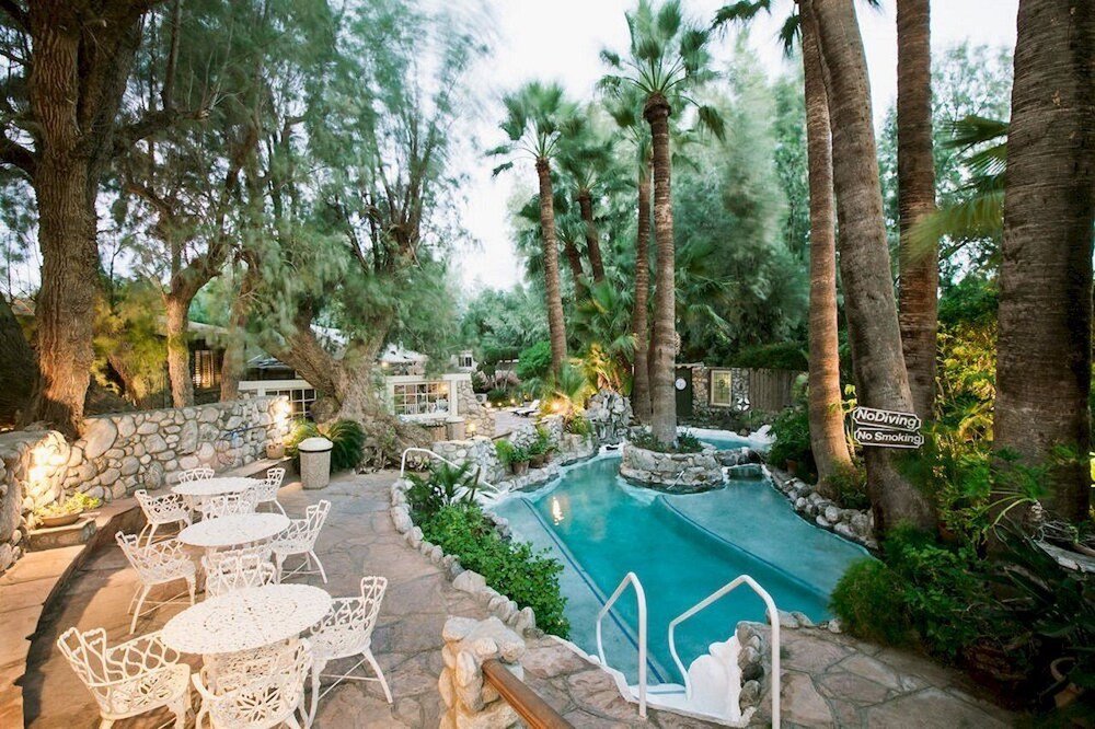 Pool area with white outdoor furniture and palm trees