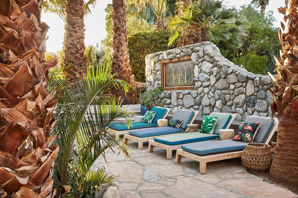 Stone wall surrounded by lounge chairs near the pools